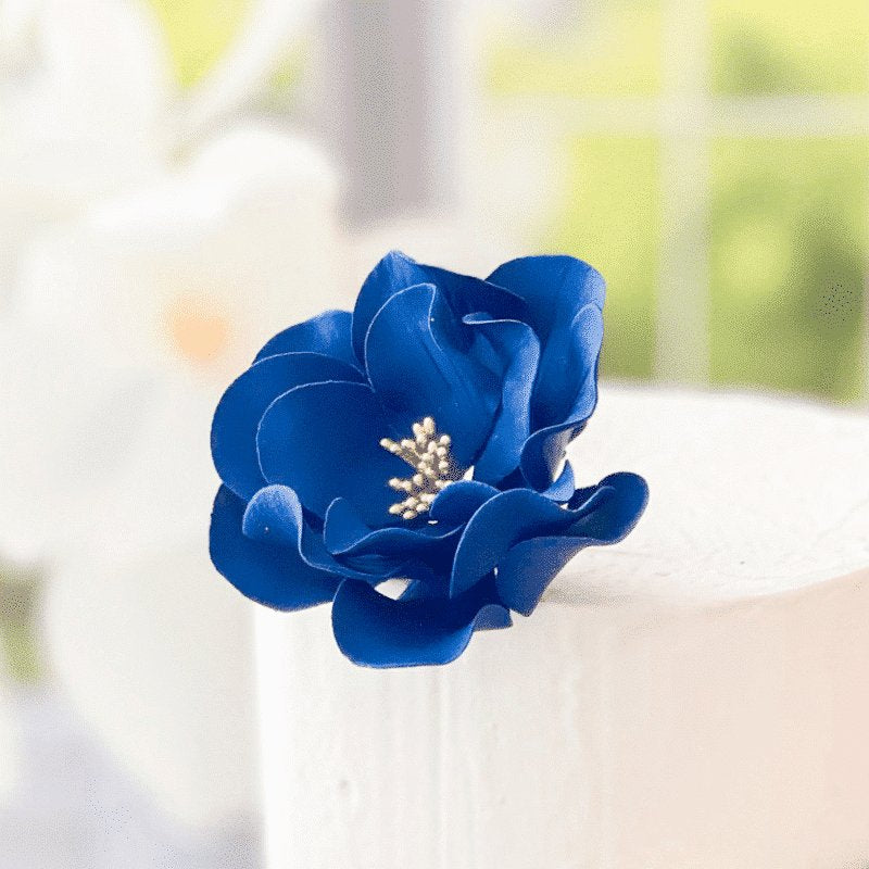 Blue flower cake topper on a blurred background