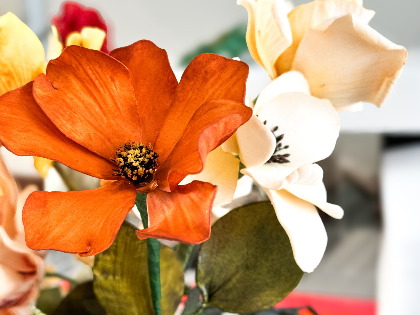 Close-up of a dark orange cosmos gumpaste flower with blurred background